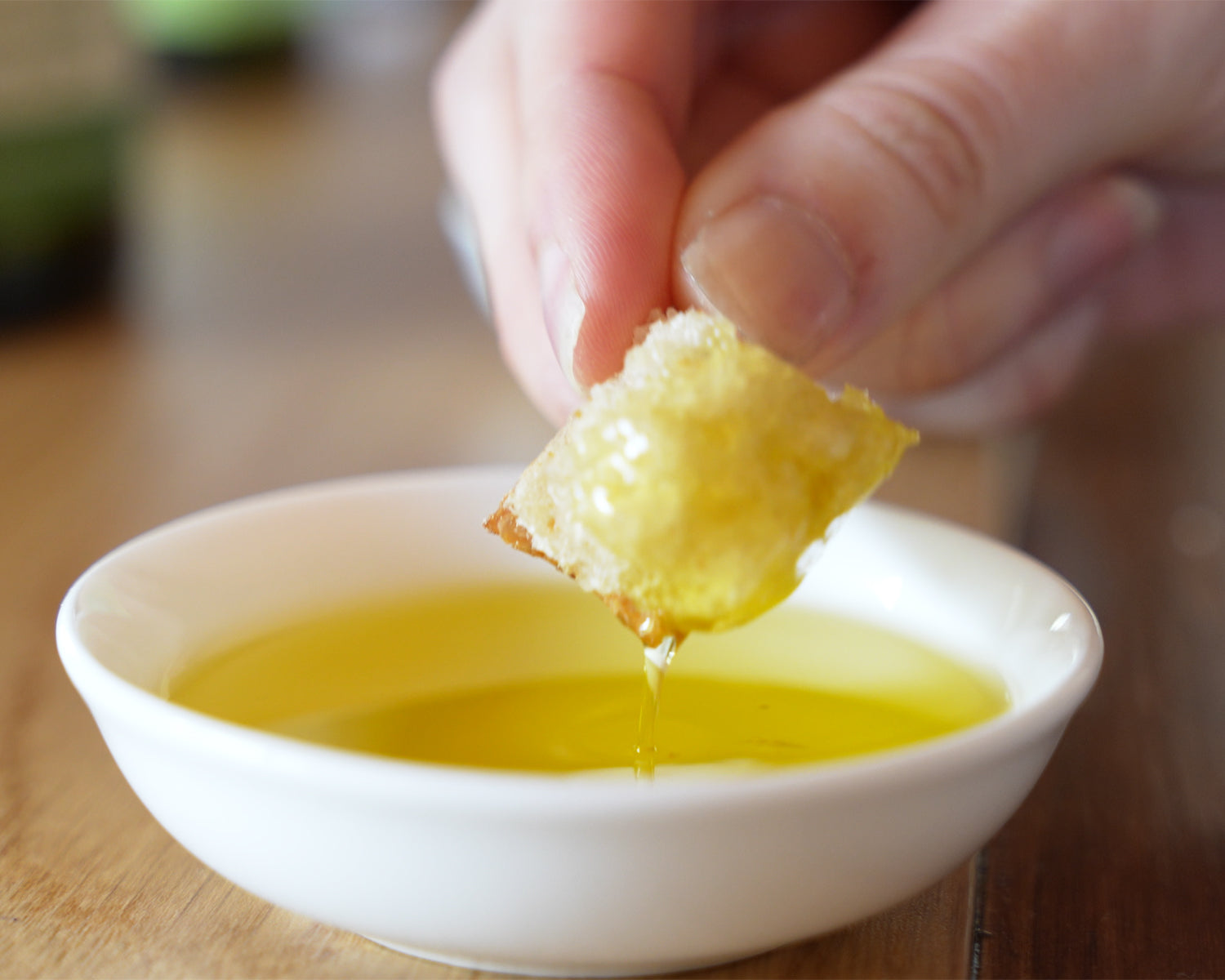 Dipping a piece of  home-made sourdough into a bowl of Allpress olive oil