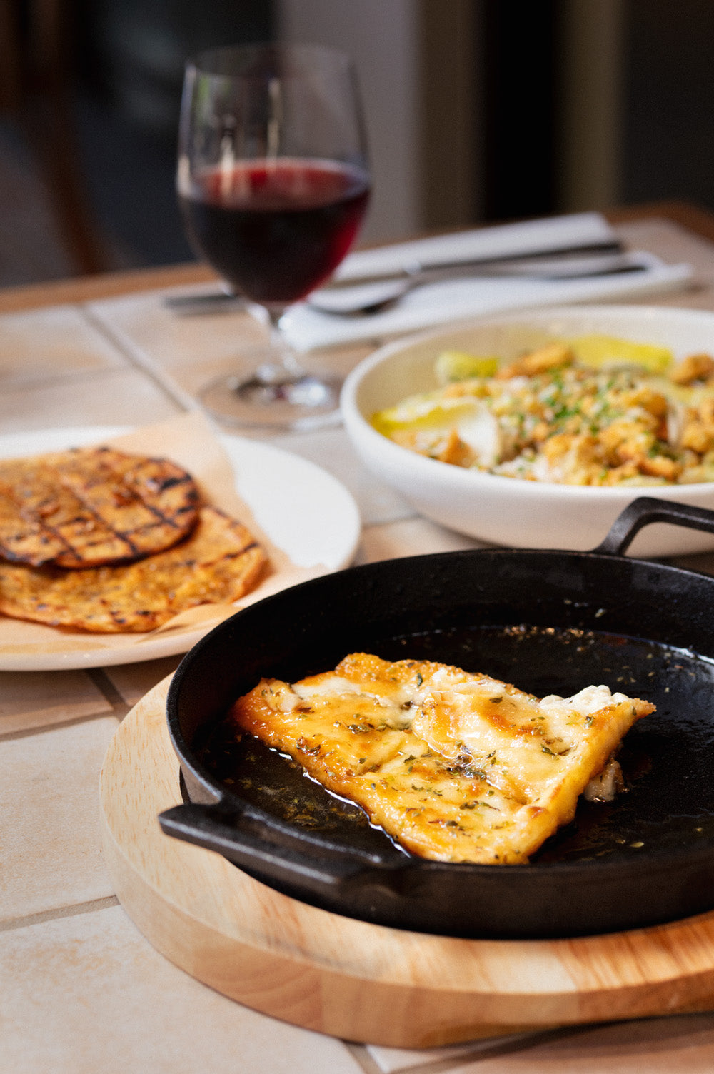 Saganaki cheese with honey and Greek oregano and side dishes served at Bistro Allpress 