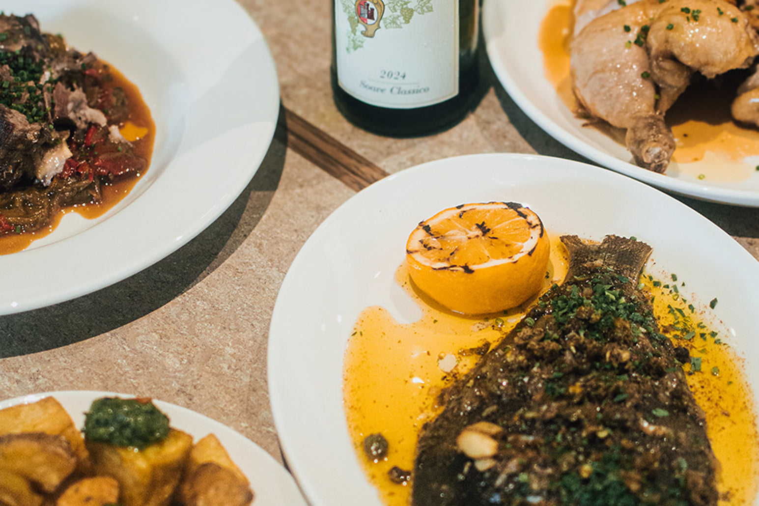 Allpress Bistro lunch dishes on a table with a bottle of wine in the background