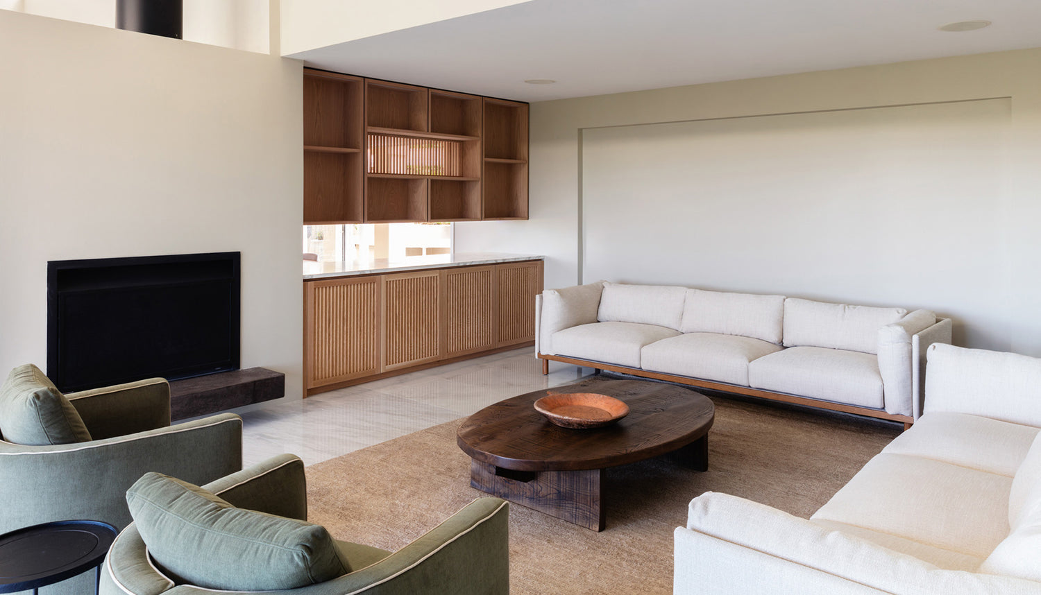 Modern living room with white sofas, a wooden coffee table, and a fireplace from The Estate, Waiheke Island