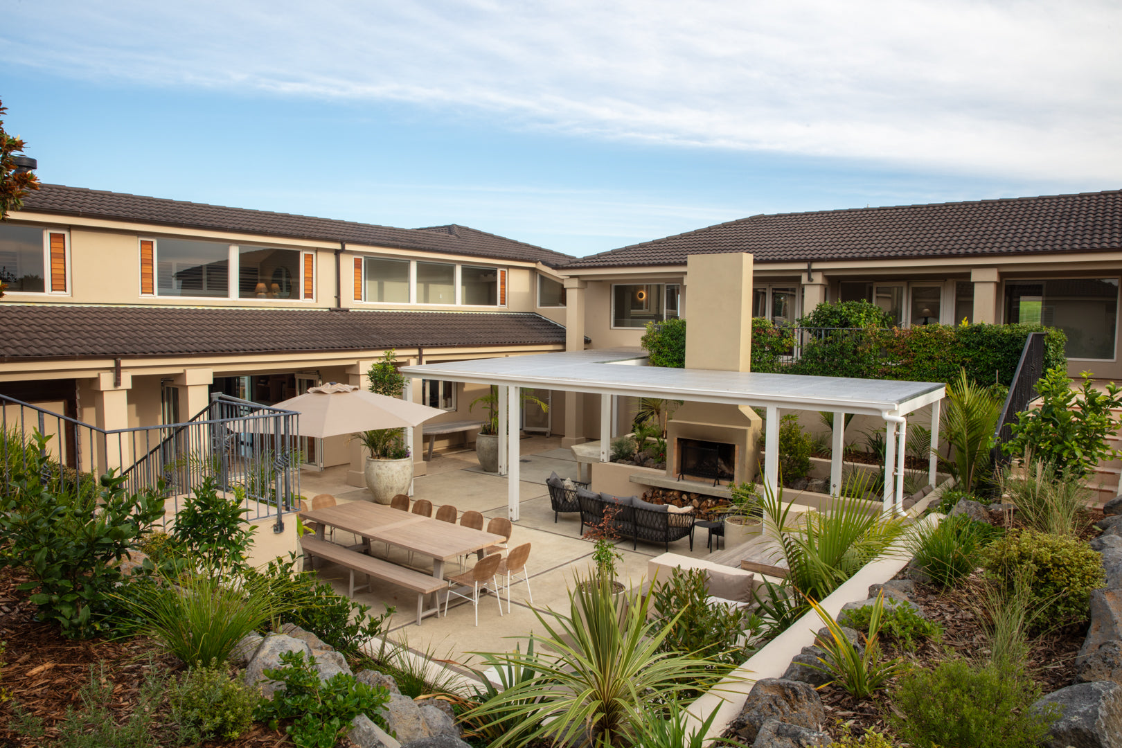 Outdoor patio with pool and lounge furniture overlooking the Hauraki Gulf