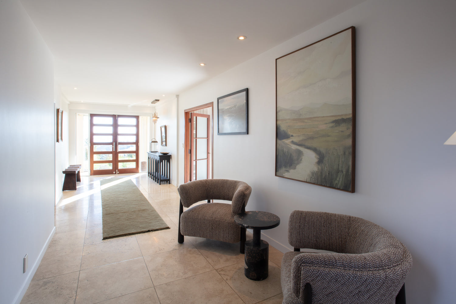 Modern living room with curved chairs and artwork at The Estate, Allpress Olive Groves, Waiheke Island